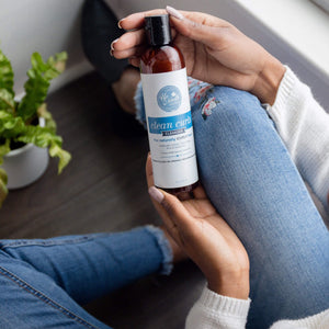 Woman holding clean curls cleanser for naturally curly hair